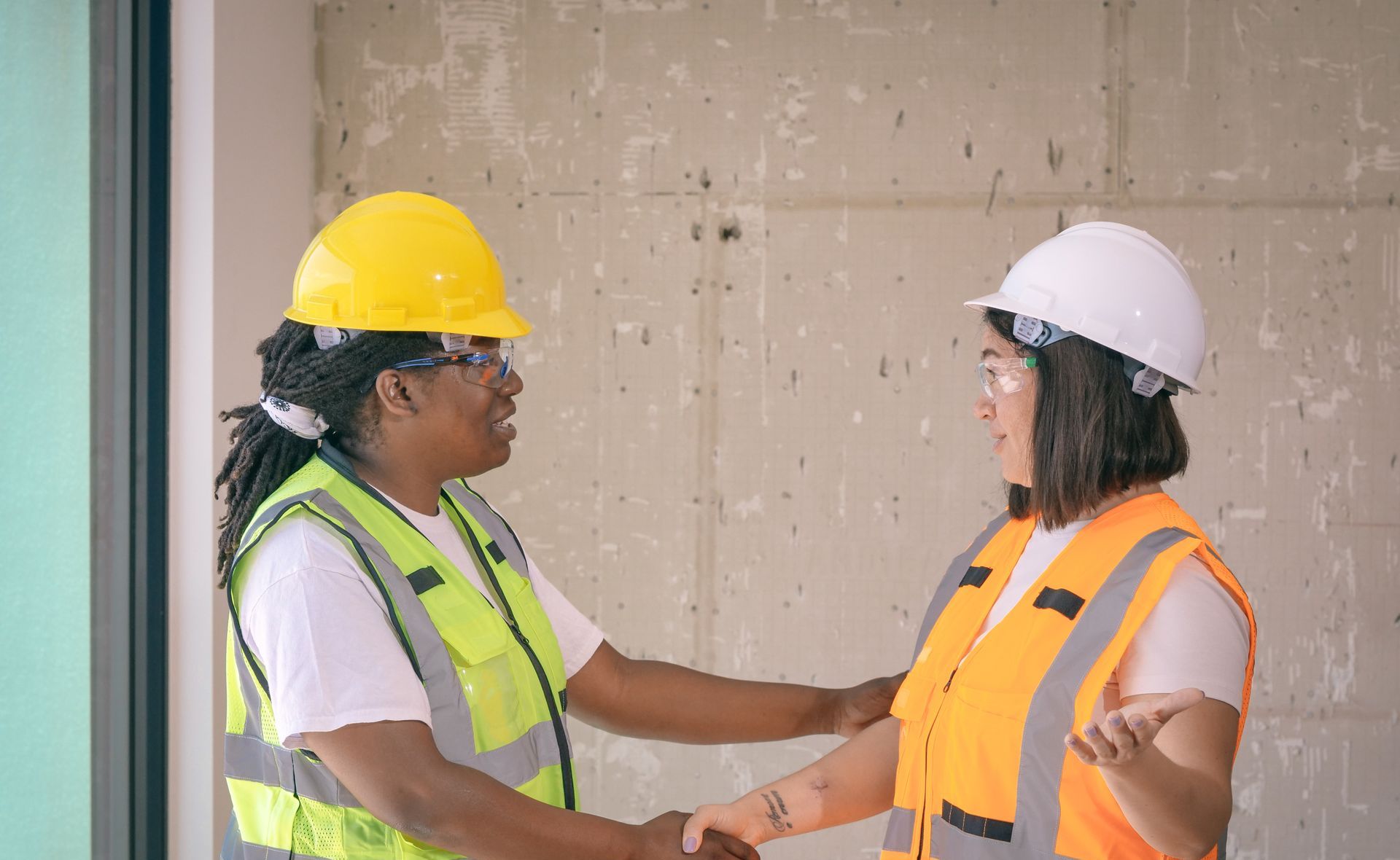 Construction workers shaking hands on a job site
