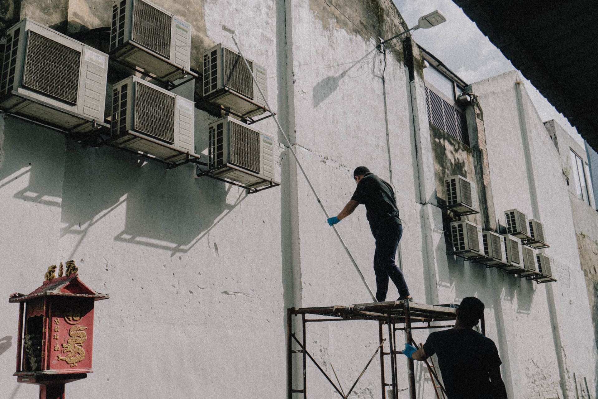 HVAC technician servicing air conditioning units on a building