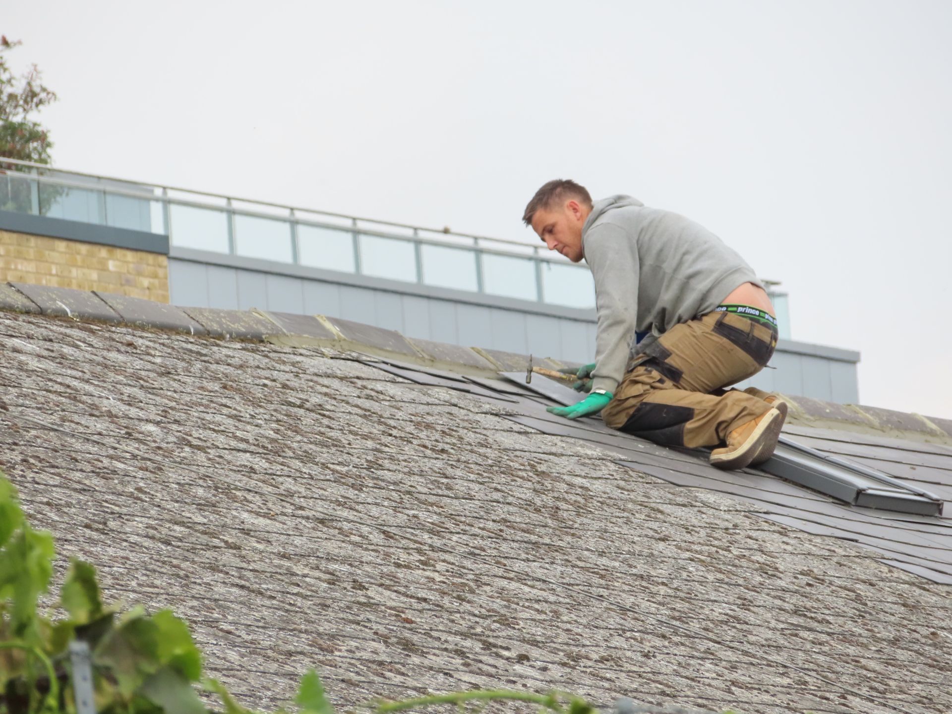 Roofer installing shingles on a residential roof